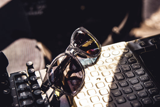 Sunglasses on an aircraft control panel surface with a blurred background