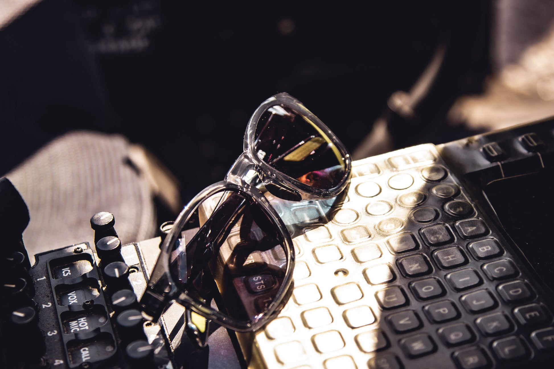 Sunglasses on an aircraft control panel surface with a blurred background