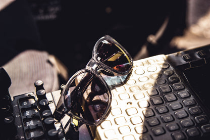 Sunglasses on an aircraft control panel surface with a blurred background
