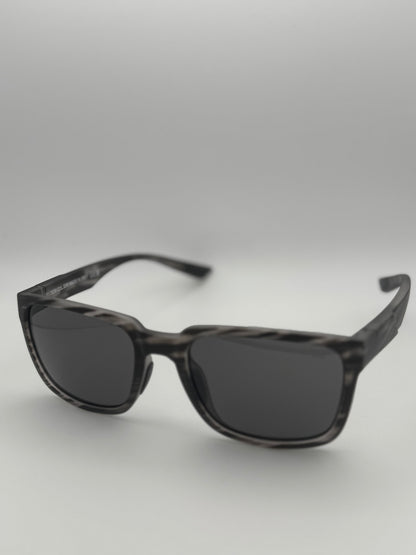 Black sunglasses with a gray gradient lens on a light gray background